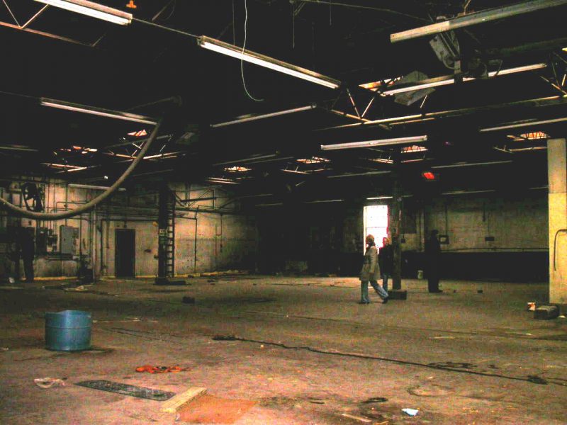 Two people walk around in an empty room