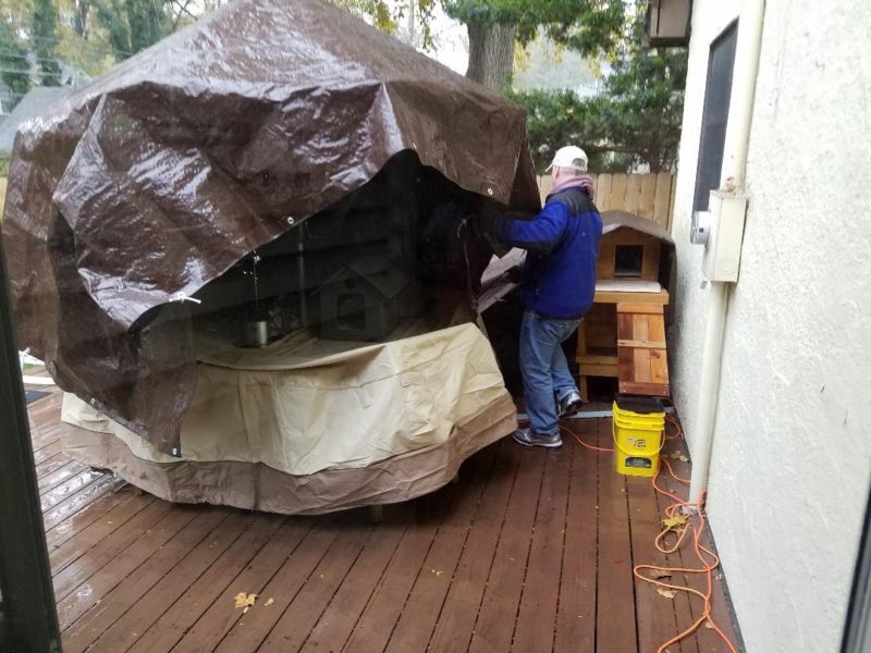 A man puts the final touches on a giant cat shelter