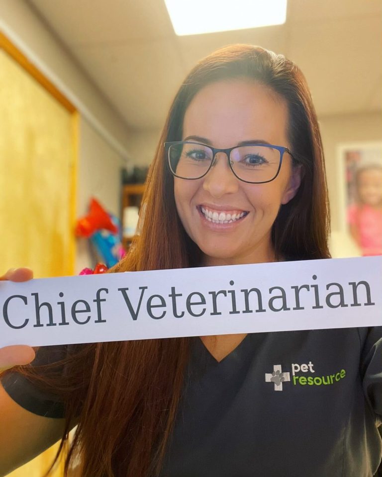 vet holding up name title that says "chief veterinarian"