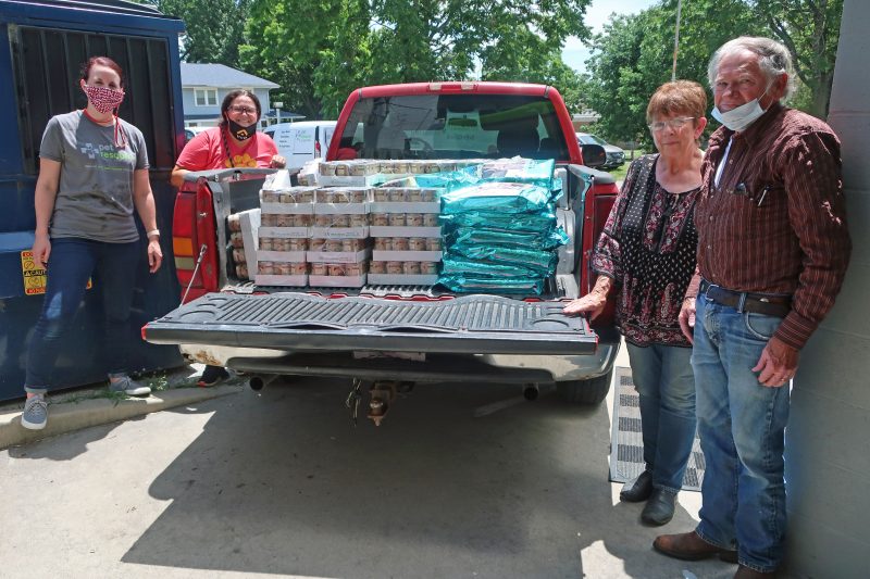 Team members filling up a truck bed with dog and cat food