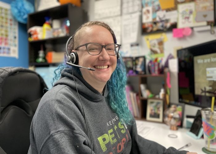 call center supervisor at her desk grinning while on the phone