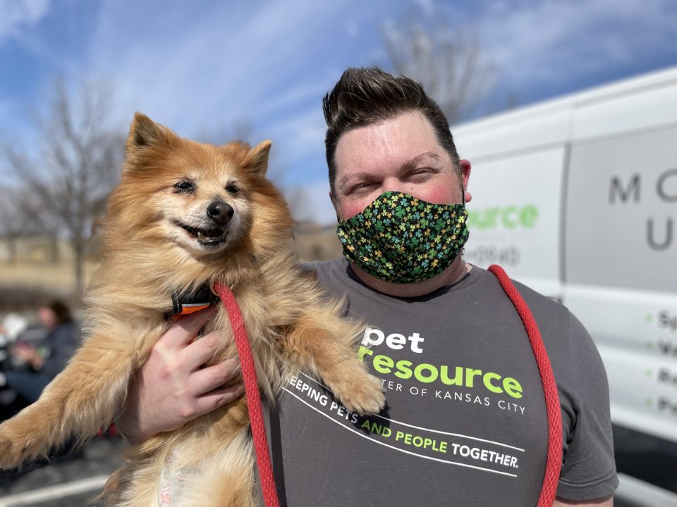 man carrying senior pomeranian to vaccinations