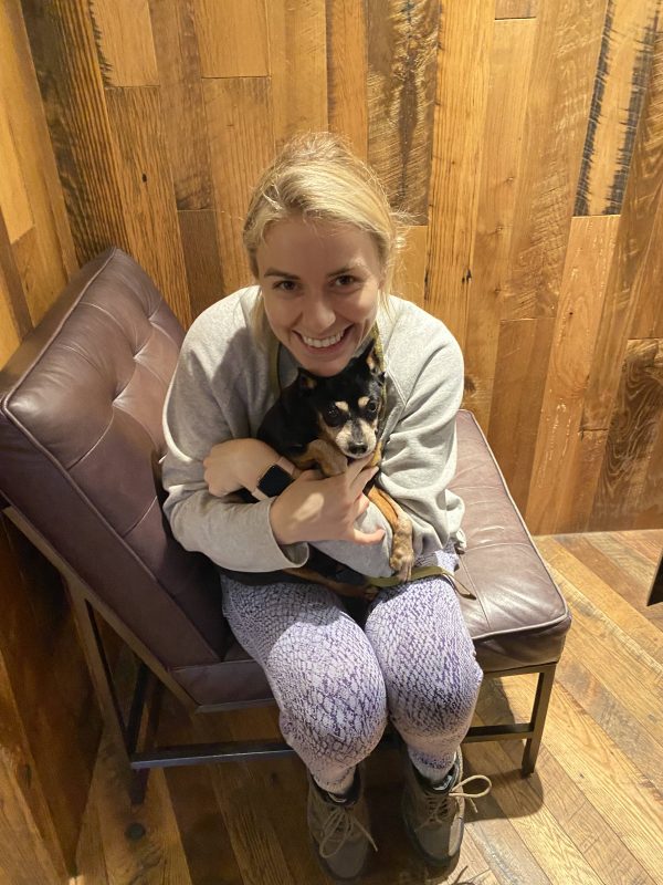 young woman hugging small dog