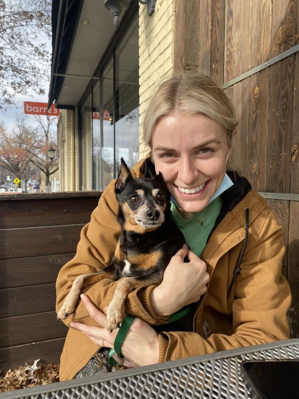 young woman hugging small senior dog