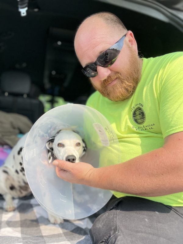 man and dog hugging after being reunited after surgery