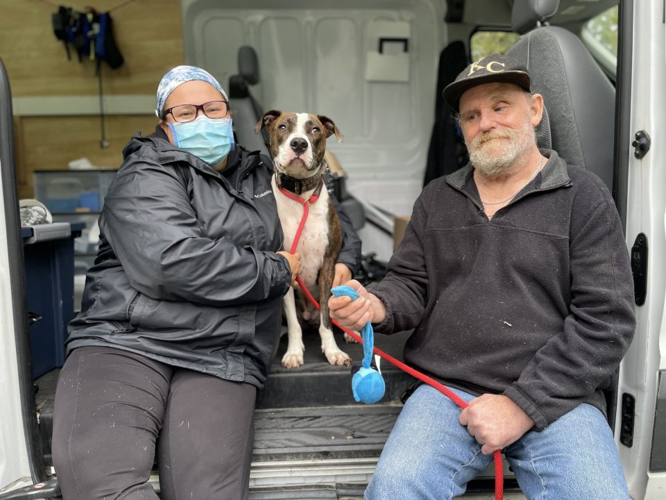 woman hugging pit bull on mobile vet visit