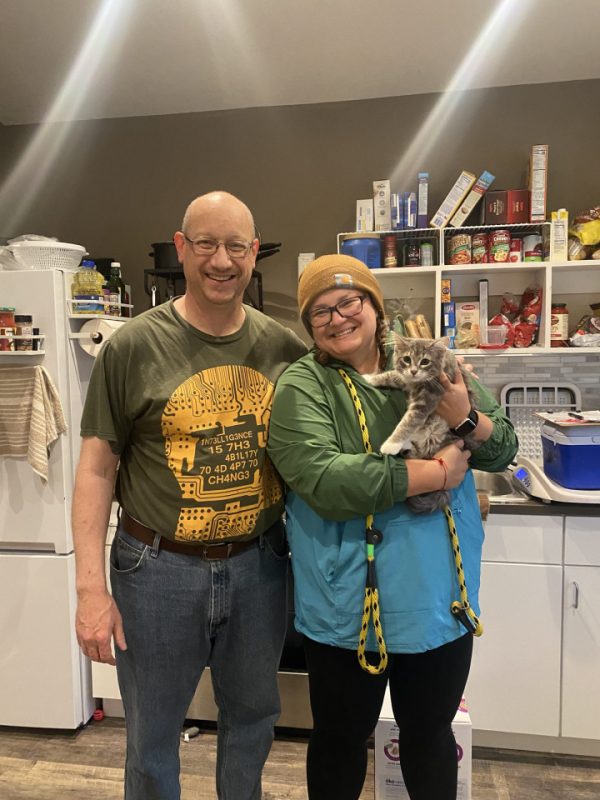 man and woman smiling holding kitten