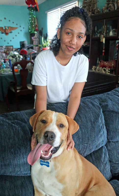 A woman and her dog look at the camera.