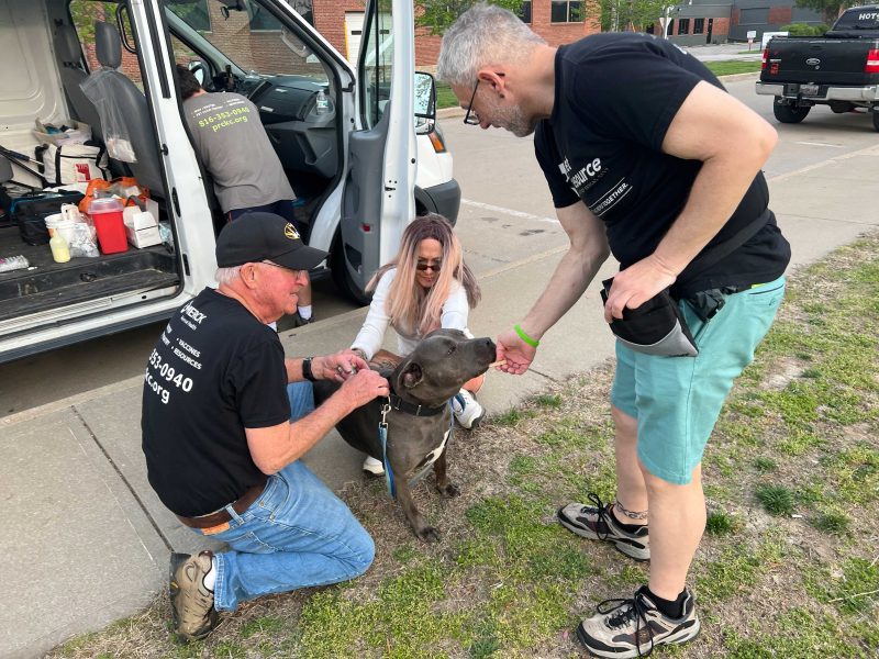Dr. Carey and Dennis work on getting a pit bull named Daisy Mae her vaccinations.