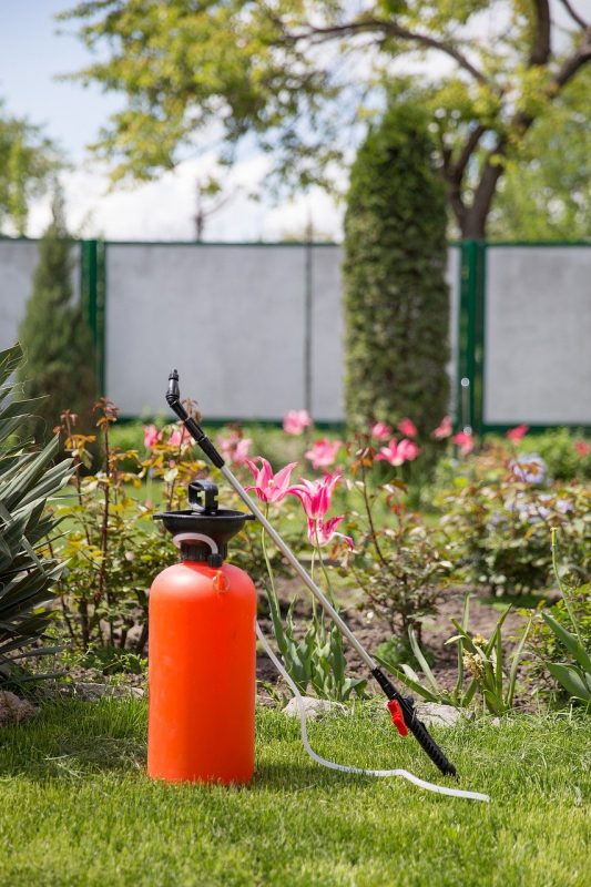 A bottle of fertilizer sits on grass