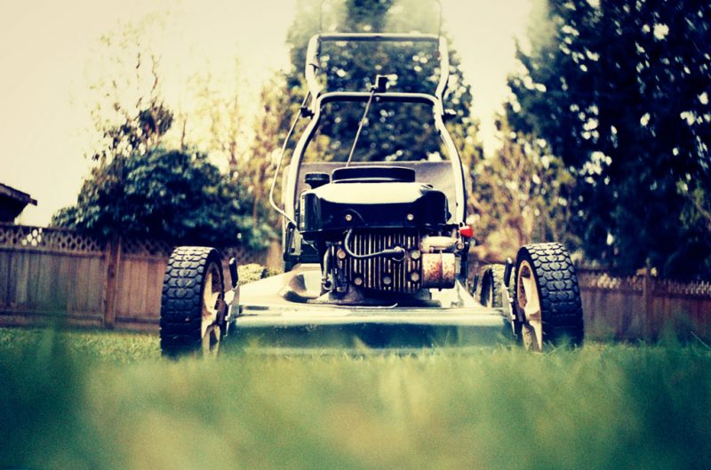 The front end of a lawnmower faces the camera