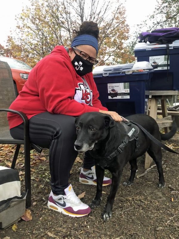 Woman petting dog with pet resources in the background