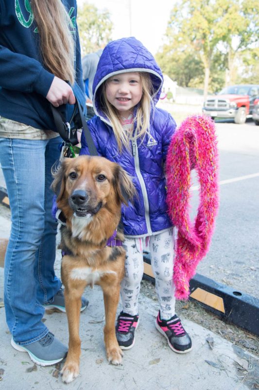 A girl and her dog look at the camera