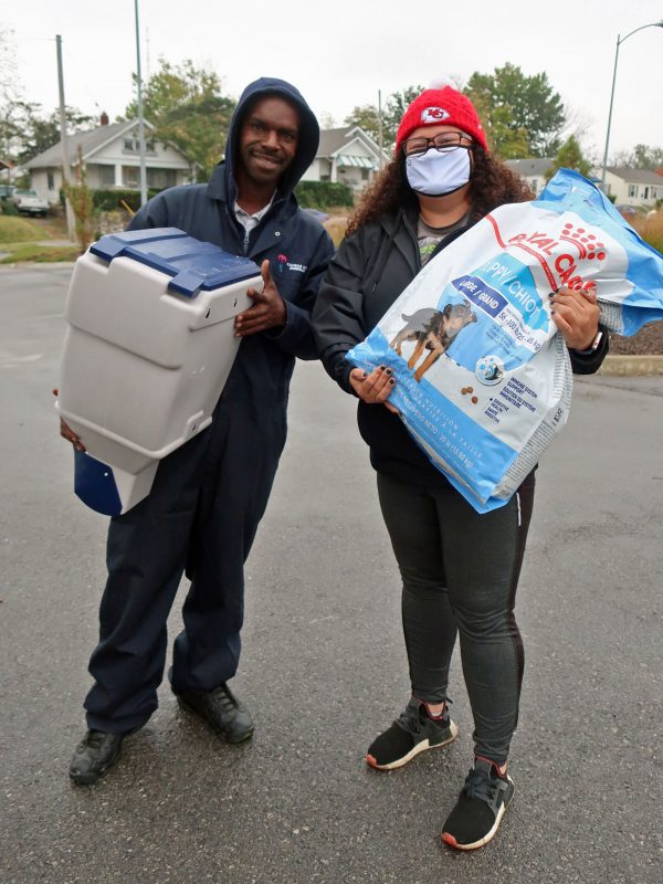 A woman and a man hold resources for pets and smile for the camera