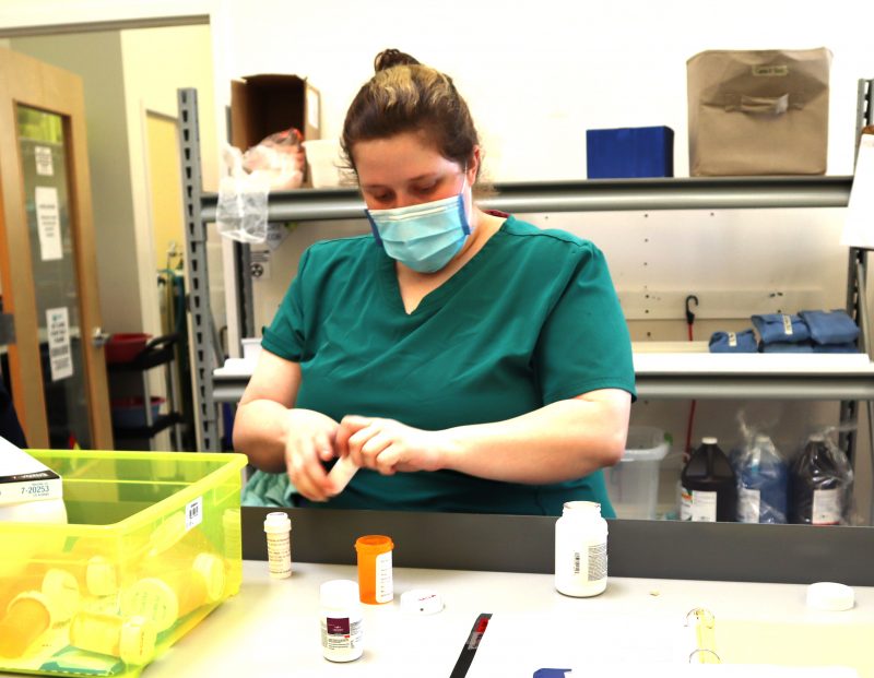 A woman handles medication bottles