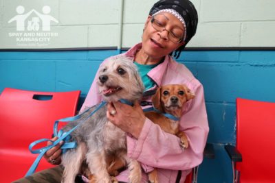 Volunteer Marise sits in Wellness Clinic with her two dogs